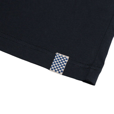 Close-up of Road Trip Black Tee showing Blue and white checkerboard woven label sewn into side seam - Slowride Supply