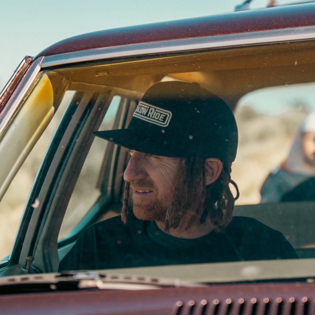 Radio Trucker Hat (Black) - Slow Ride- Black Slow Ride mesh trucker hat featuring bold logo, perfect for Volkswagen bus and vintage Volkswagen enthusiasts. Ideal for off-roading, off-road racing, and Baja bug fans. A staple accessory for the Garage and Racing lifestyle, whether you're enjoying getting there or engaging in wheelin' and spilling. This hat embodies the spirit of restore and destroy, making it a must-have for blue-collar workwear. Elevate your style with this durable, comfortable Slow Ride hat 